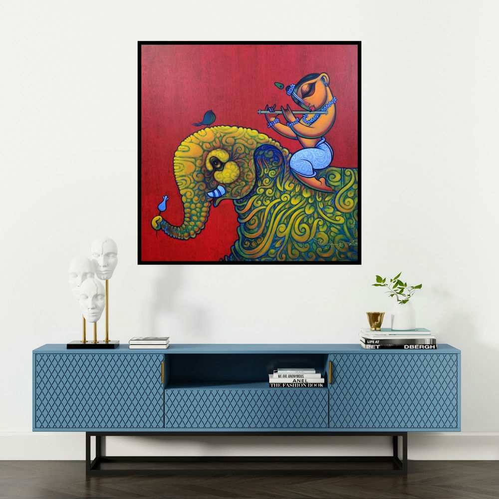 'Playing Flute On Elephant 1 (Elephant Serenade)' painting by Ramesh Gujar shown on a wall in a furnished room.