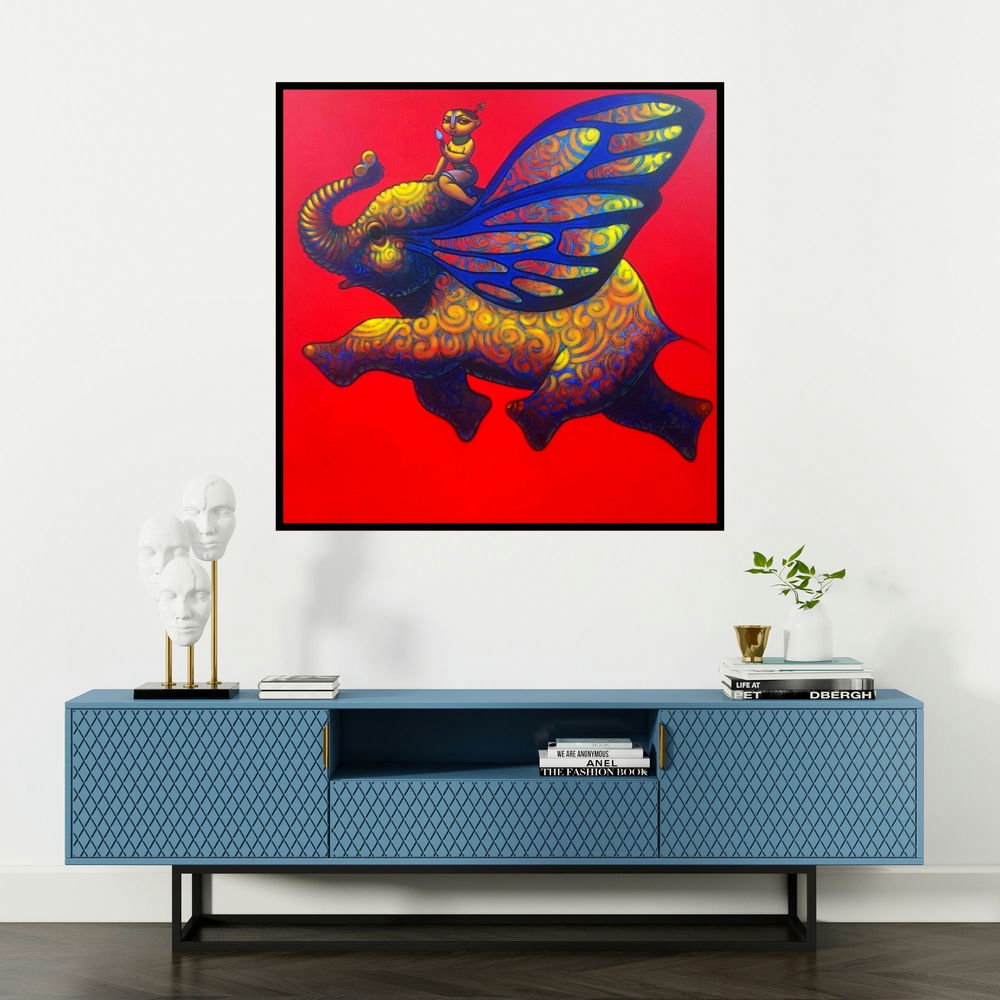 'Playing Flute On Elephant 2 (Flight of Fancy)' painting by Ramesh Gujar shown on a wall in a furnished room.